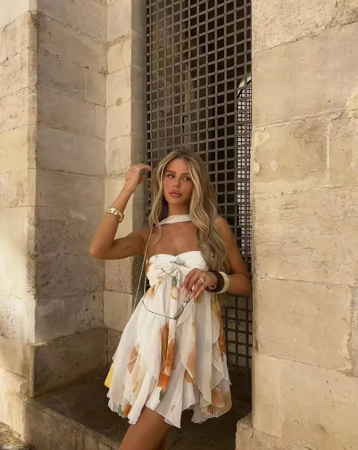 Robe mini blanche en tissu léger avec imprimé floral orange et manches courtes, idéale pour les journées d'été.