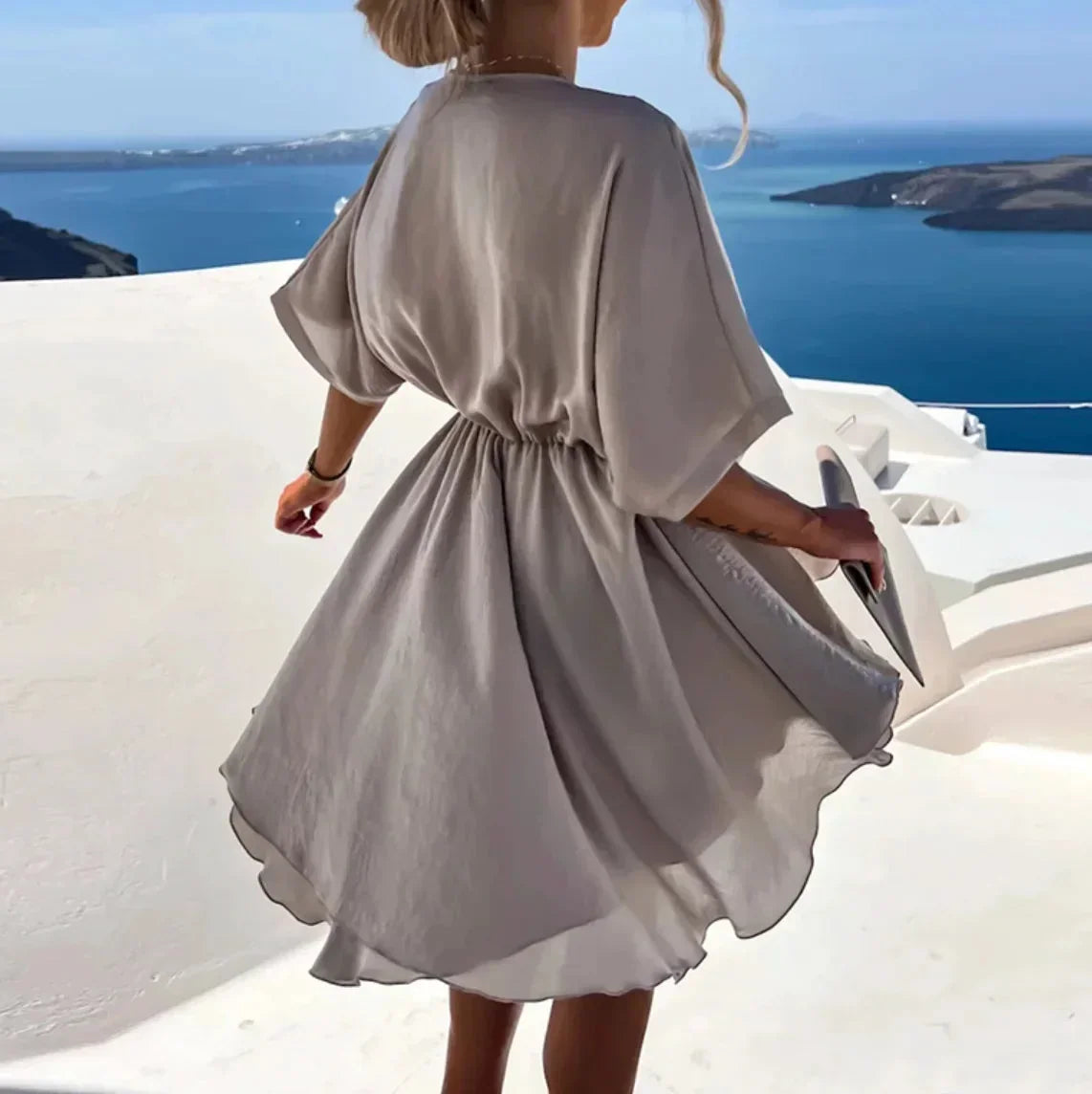 Robe courte fluide en tissu léger avec col V, cache-cœur et manches courtes, idéale pour une journée à la plage.