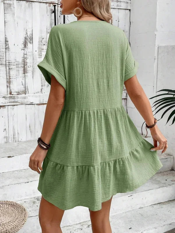 Robe courte fluide à volants superposés, col V, manches courtes, en tissu léger, idéale pour les journées d'été.