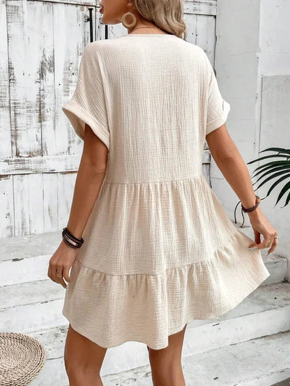 Robe courte fluide à volants superposés, col V, manches courtes, en coton léger, parfaite pour l'été. Disponible en plusieurs…