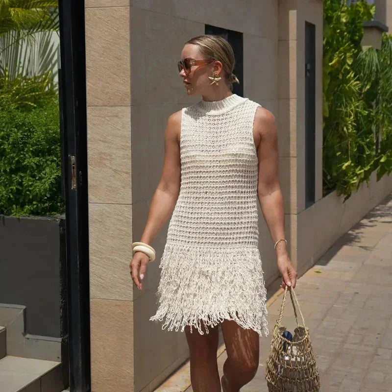 Robe sans manches en maille ivoire, ornée de franges, idéale pour un look décontracté à la plage cet été.