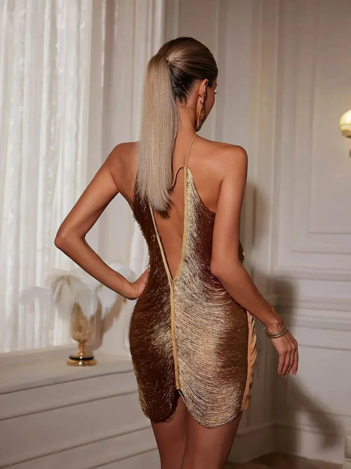 Robe courte en matériau métallique, design asymétrique avec fermeture éclair au dos, idéale pour les soirées en club.