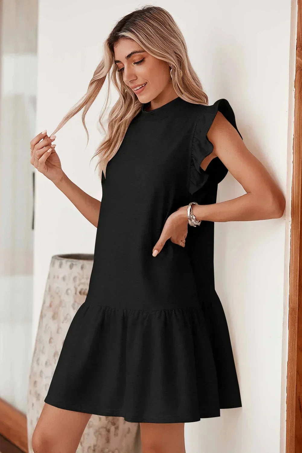 Robe courte noire à volants, manches courtes, coupe trapèze en polyester léger, parfaite pour les soirées estivales.