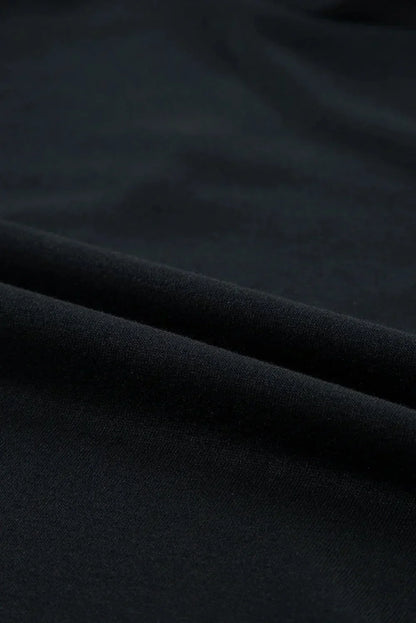 Robe courte noire en polyester avec volants, manches courtes et coupe trapèze, idéale pour des soirées décontractées.