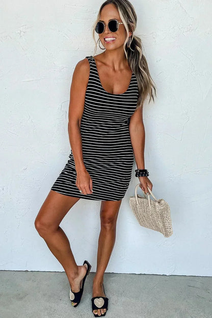 Robe courte rayée bleu marine et blanc, sans manches, en coton léger, parfaite pour des journées d'été à la plage.