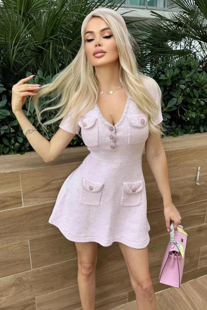 Robe courte rose à manches courtes, col V, avec poches, coupe ajustée, en tissu léger idéal pour l'été.