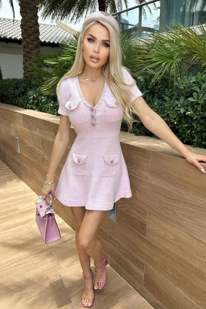Robe courte rose en coton avec boutons, poches, manches courtes et col V, idéale pour un look estival décontracté.