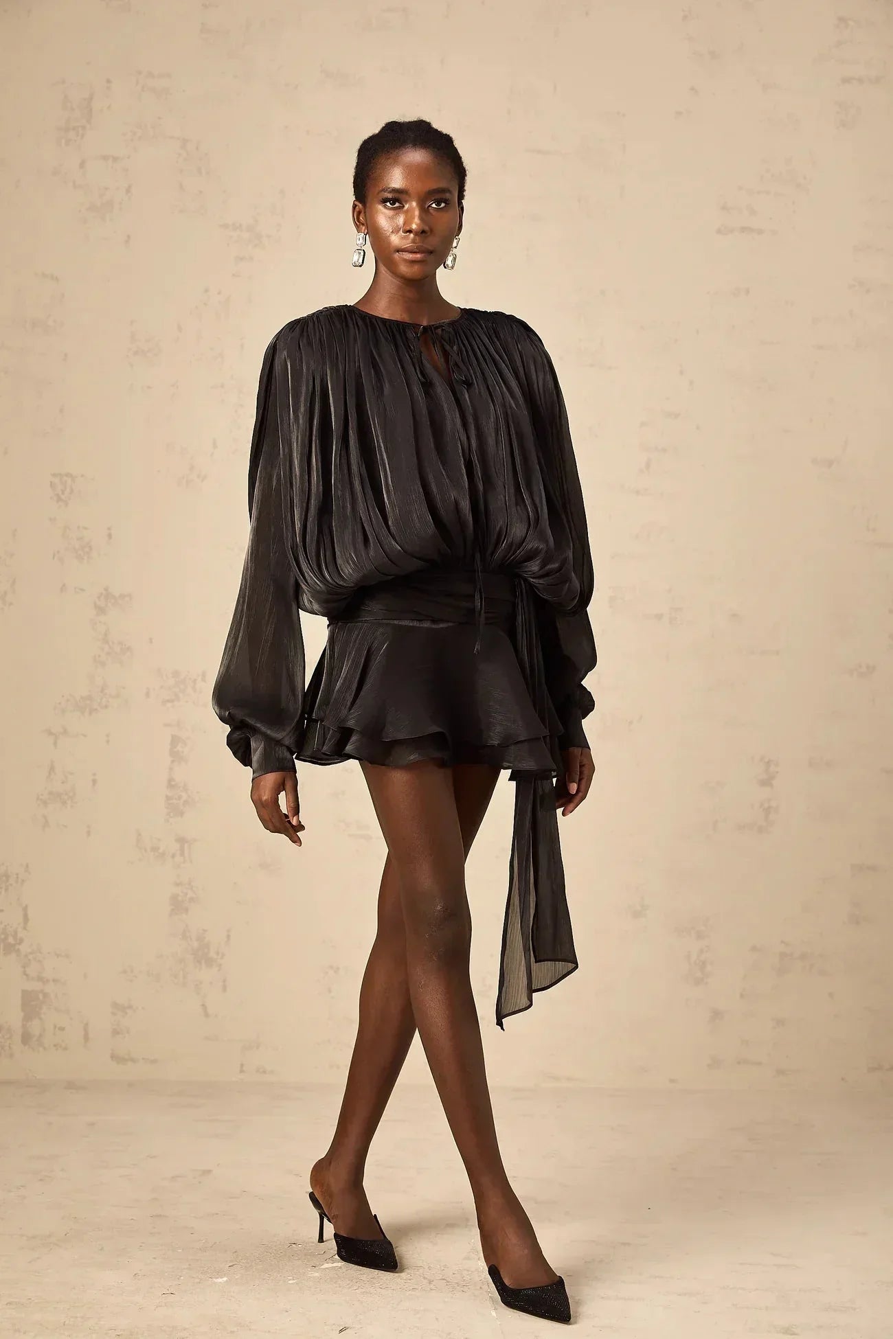 Robe courte fluide en satin, manches longues avec nœuds, parfaite pour les soirées. Disponible en plusieurs couleurs.