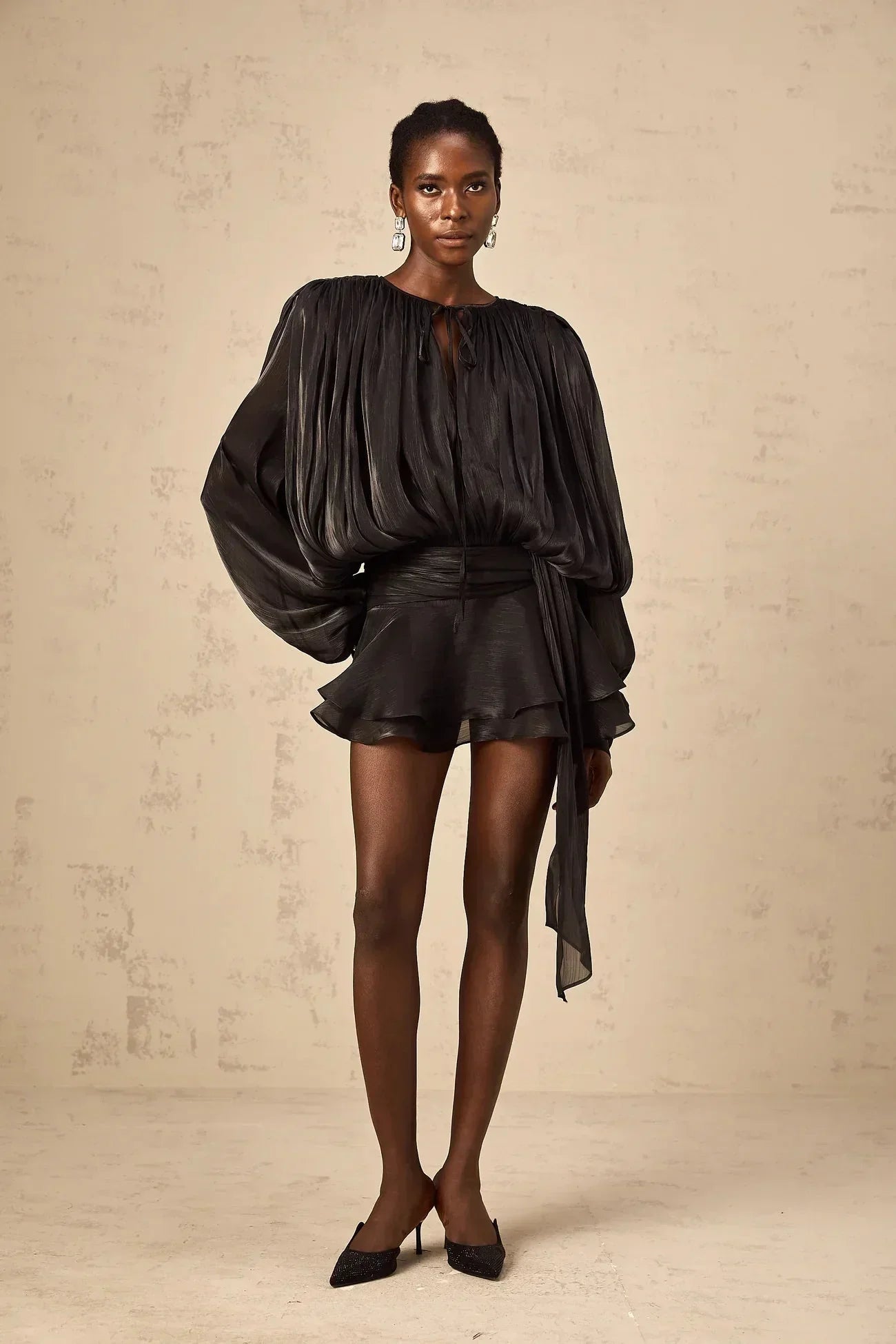 Robe courte satinée avec nœuds aux manches longues, fluide et élégante, disponible en plusieurs couleurs.