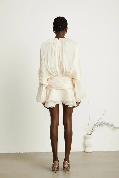 Robe courte satinée fluide avec nœuds aux manches longues, disponible en plusieurs couleurs, idéale pour les soirées.