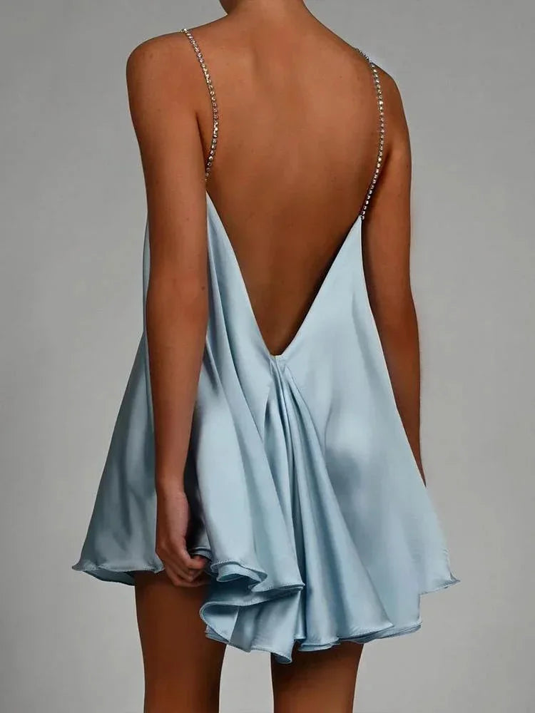 Robe courte satinée fluide avec des chaînes décoratives, tissu léger et design élégant, idéale pour les soirées.
