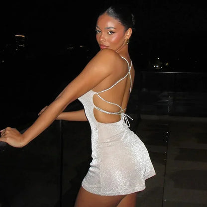 Robe courte en sequins, dos nu avec bretelles croisées, idéale pour soirées clubbing, tissu brillant et ajustement confortable.