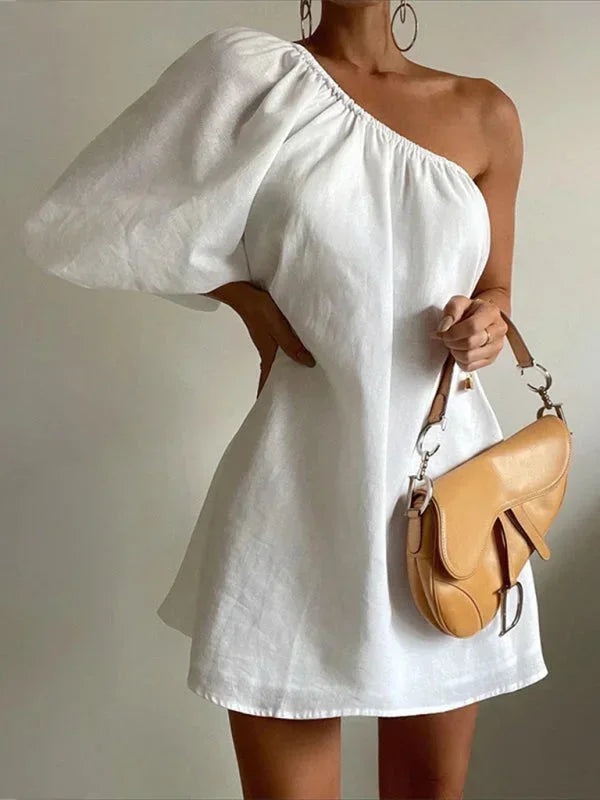 Robe courte une épaule en tissu léger avec manche bouffante, idéale pour les soirées d'été. Design élégant et pratique.