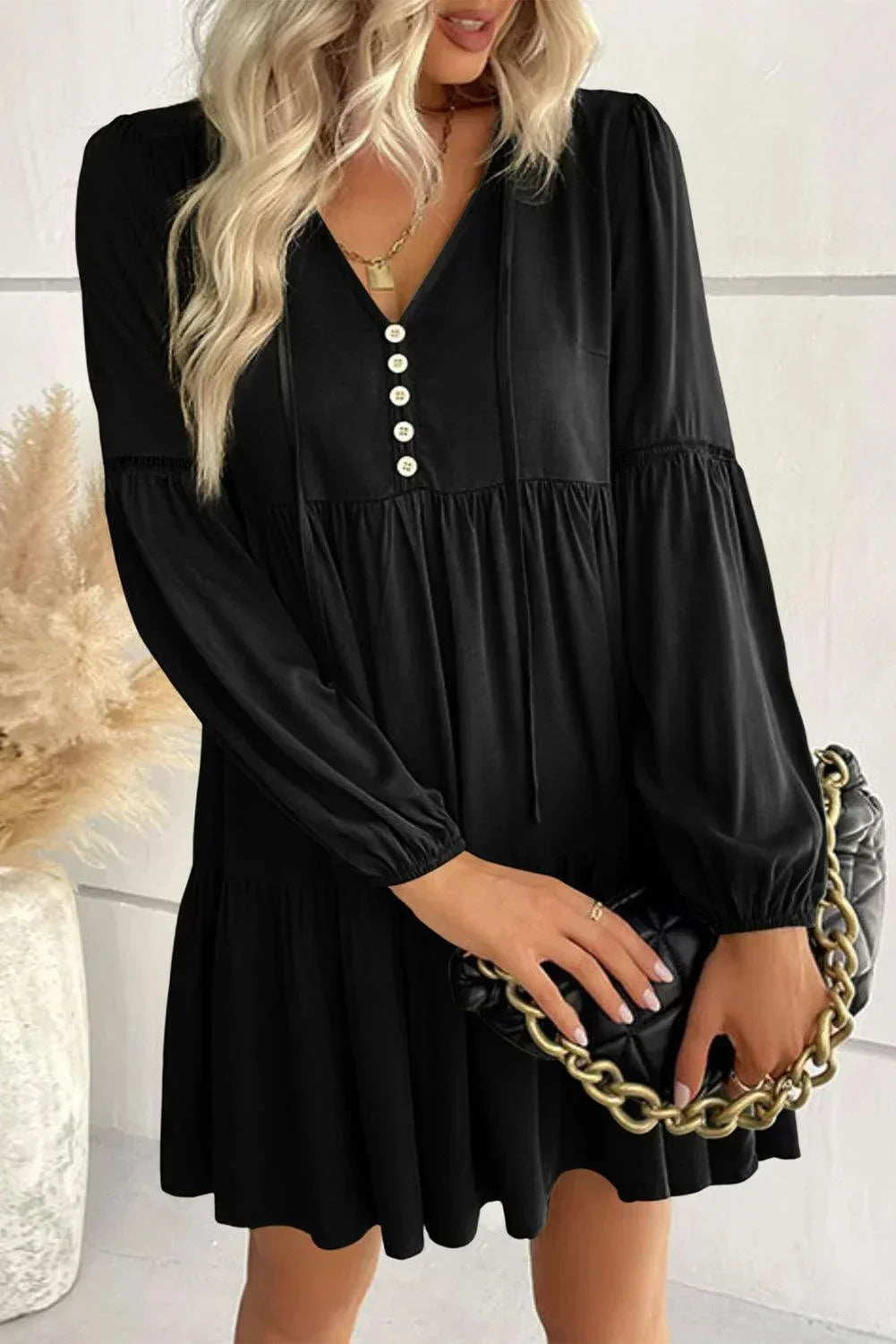 Robe courte volantée à lacets, manches longues, en tissu doux, avec un style automnal et des détails élégants sur les manches.