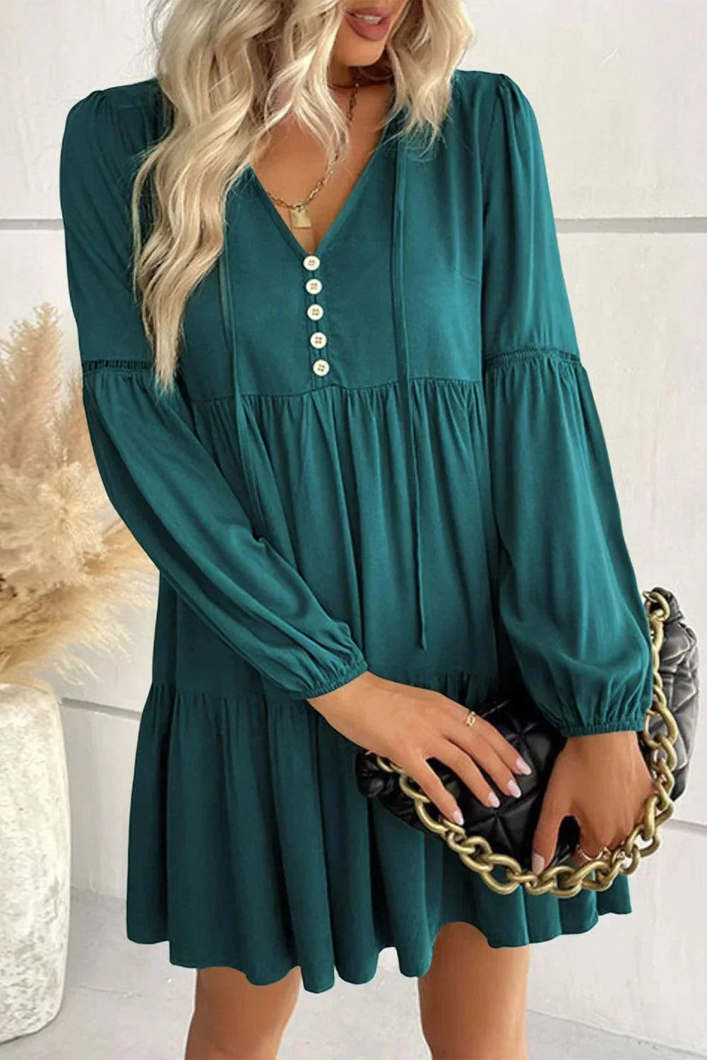 Robe courte en tissu léger avec volants, lacets décoratifs et manches longues, idéale pour les journées douces d'automne.