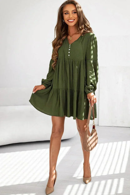 Robe courte volantée à lacets, manches longues en coton, avec un design automnal et une coupe fluide.