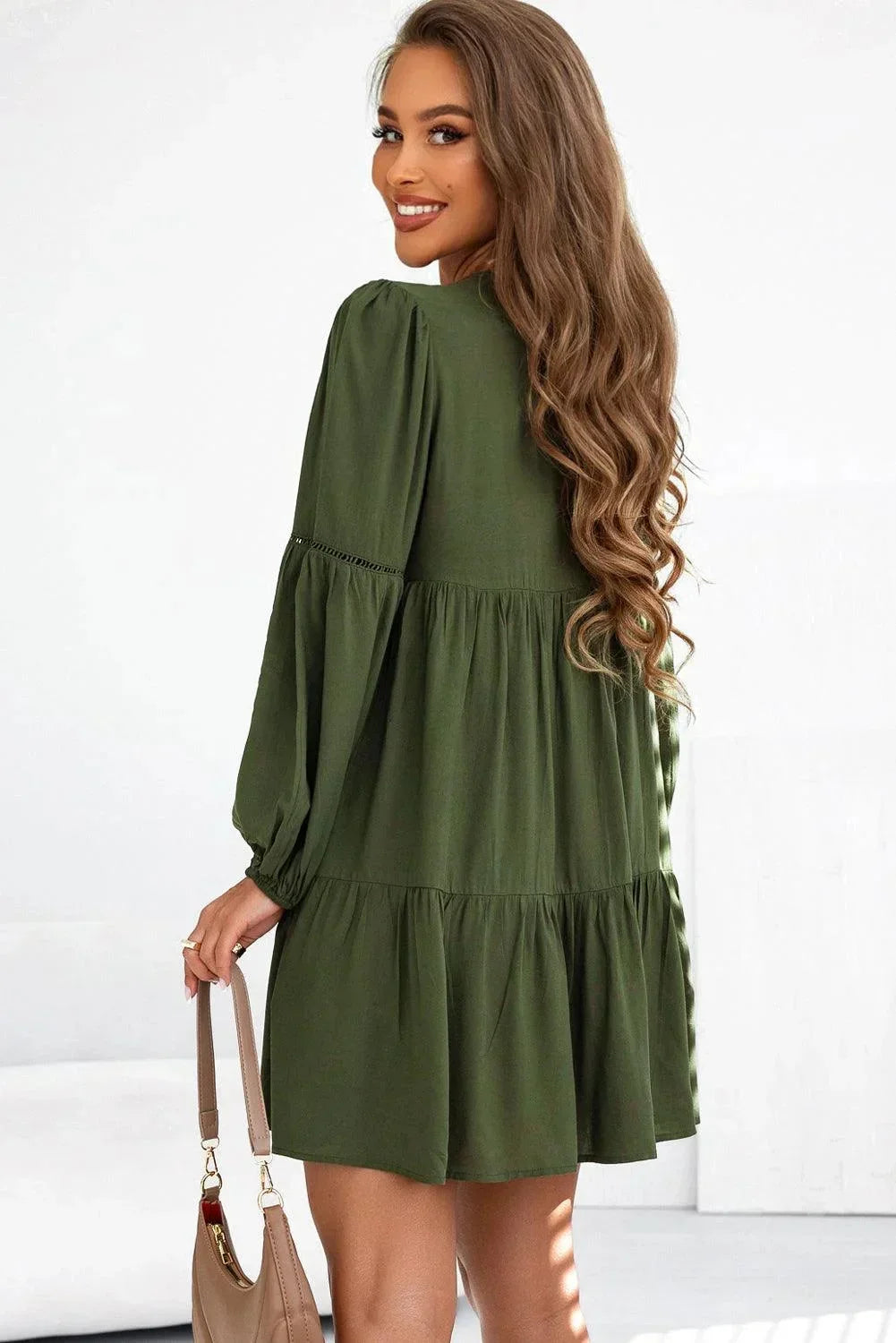 Robe courte volantée à lacets, en tissu léger, avec des manches longues pour un look automnal élégant et décontracté.