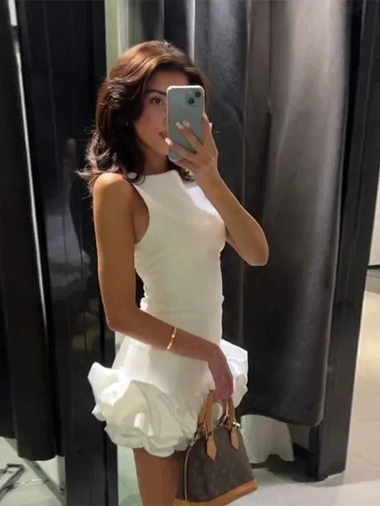 Robe courte volantée sans manches en coton léger, avec un design fluide et disponible en plusieurs couleurs vives.