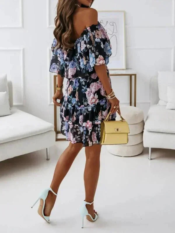 Robe courte à volants avec fleurs, épaules dénudées, en tissu léger et fluide, idéale pour les journées estivales.