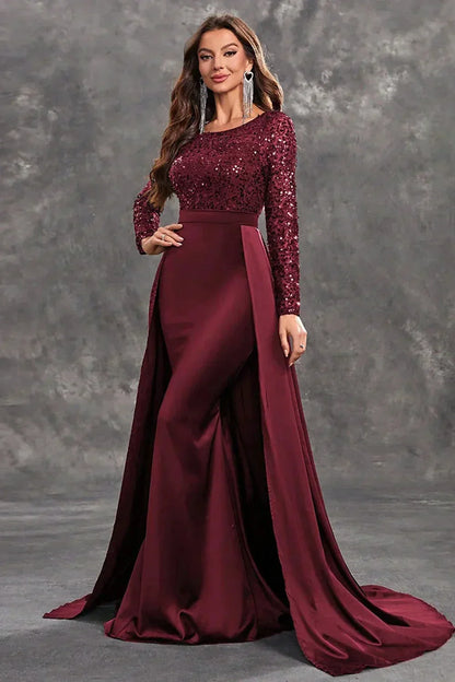 Robe soirée longue en tissu fluide, ornée de sequins, avec une silhouette élégante et une jupe flottante.
