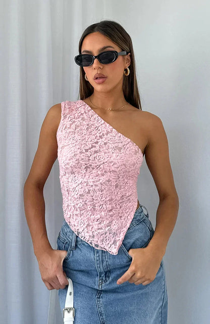 Top asymétrique en dentelle rose avec texture délicate et manches courtes, parfait pour une tenue élégante et féminine.