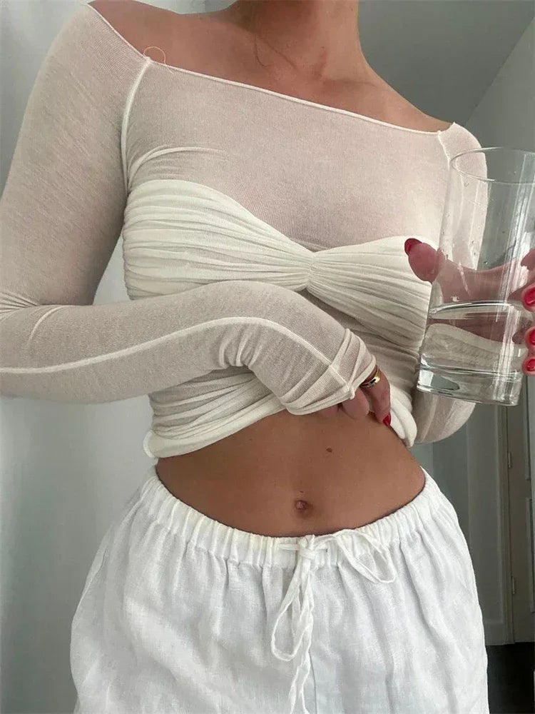 Top femme en maille blanche transparente avec détail torsadé pour un style contemporain.