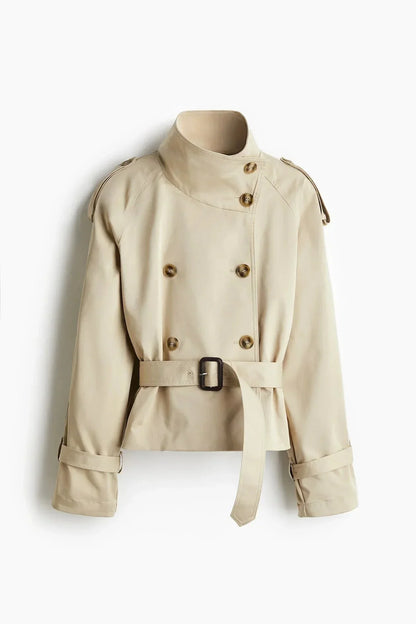 Trench-coat femme à col montant, ceinture nouée, en tissu résistant, adapté aux saisons intermédiaires.