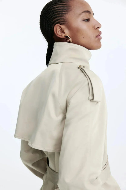 Trench-coat femme noir avec col montant et ceinture nouée, en matériau léger et résistant aux intempéries.