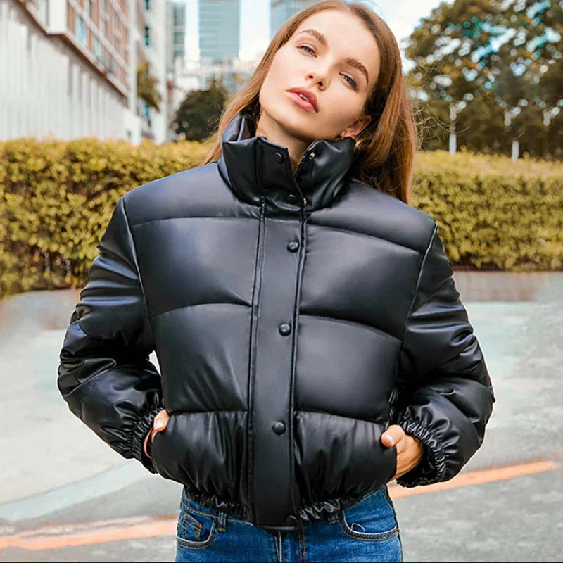 Doudoune d'hiver noire pour femme, avec capuche, fermeture à glissière et poches latérales.