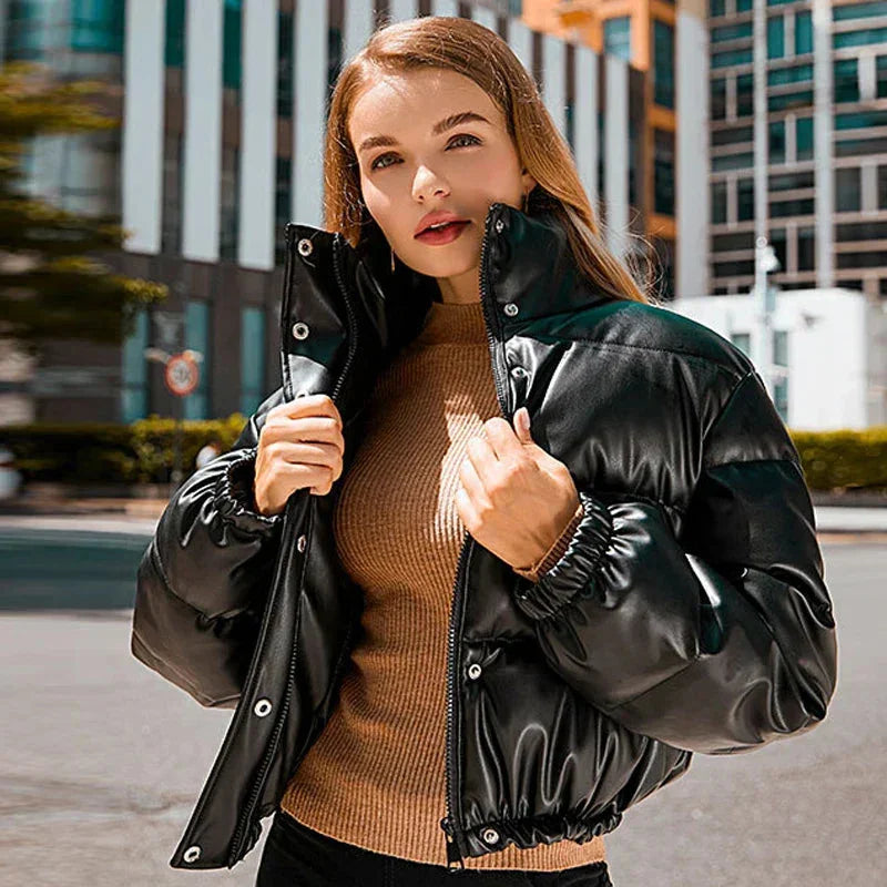 Doudoune d'hiver noire pour femme, avec capuche, fermeture à glissière et design matelassé.