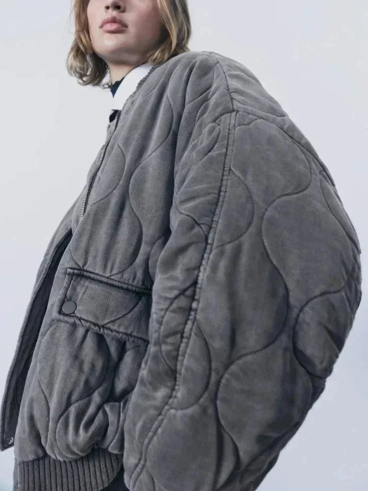 Veste bomber femme oversize matelassée noire avec boutons-pression en tissu résistant.