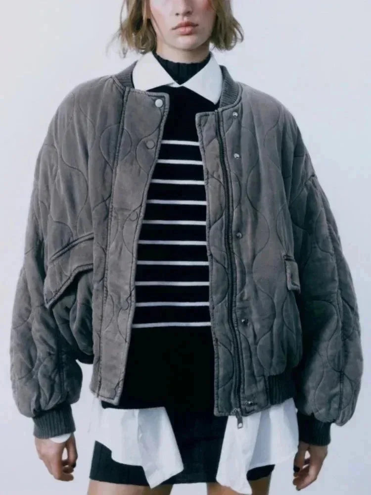 Veste bomber femme oversize matelassée noire avec boutons-pression et design moderne.