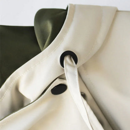 Veste coupe-vent blanche pour femme, avec capuche amovible, coupe sportive et poches pratiques.