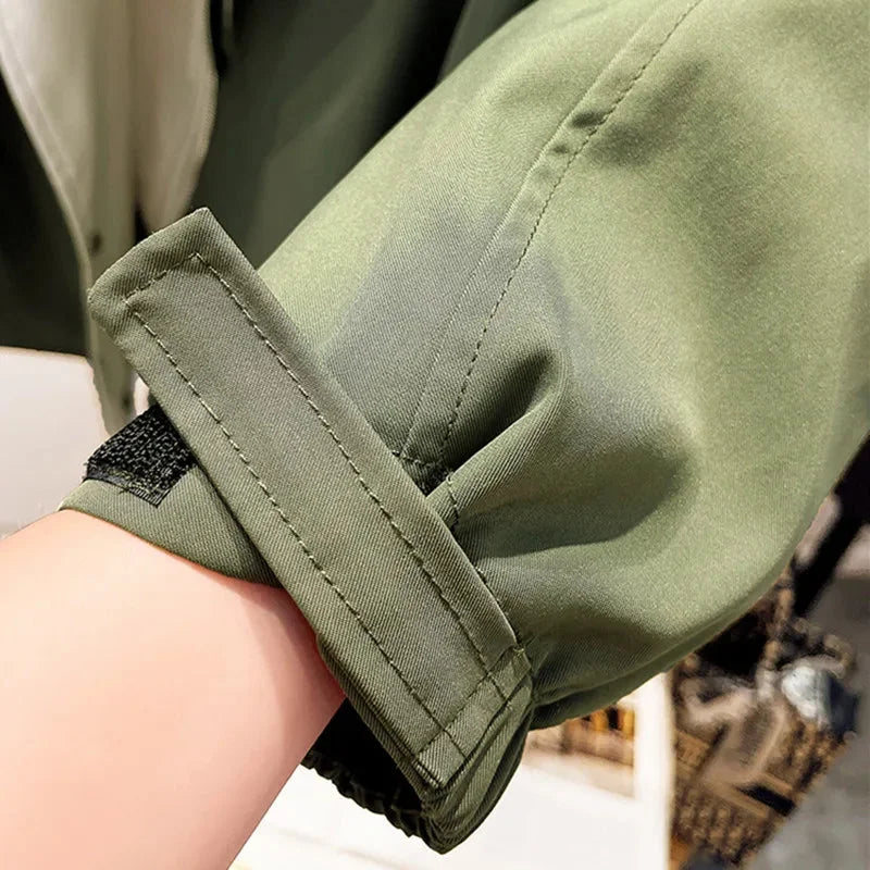 Veste coupe-vent femme verte, légère, avec capuche amovible, coupe sportive et poches pratiques.