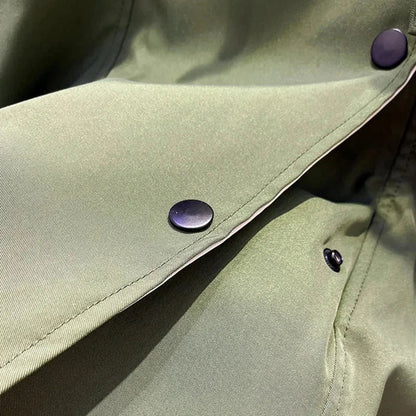 Veste coupe-vent femme verte, légère, avec capuche amovible et imperméable, adaptée aux activités en extérieur.
