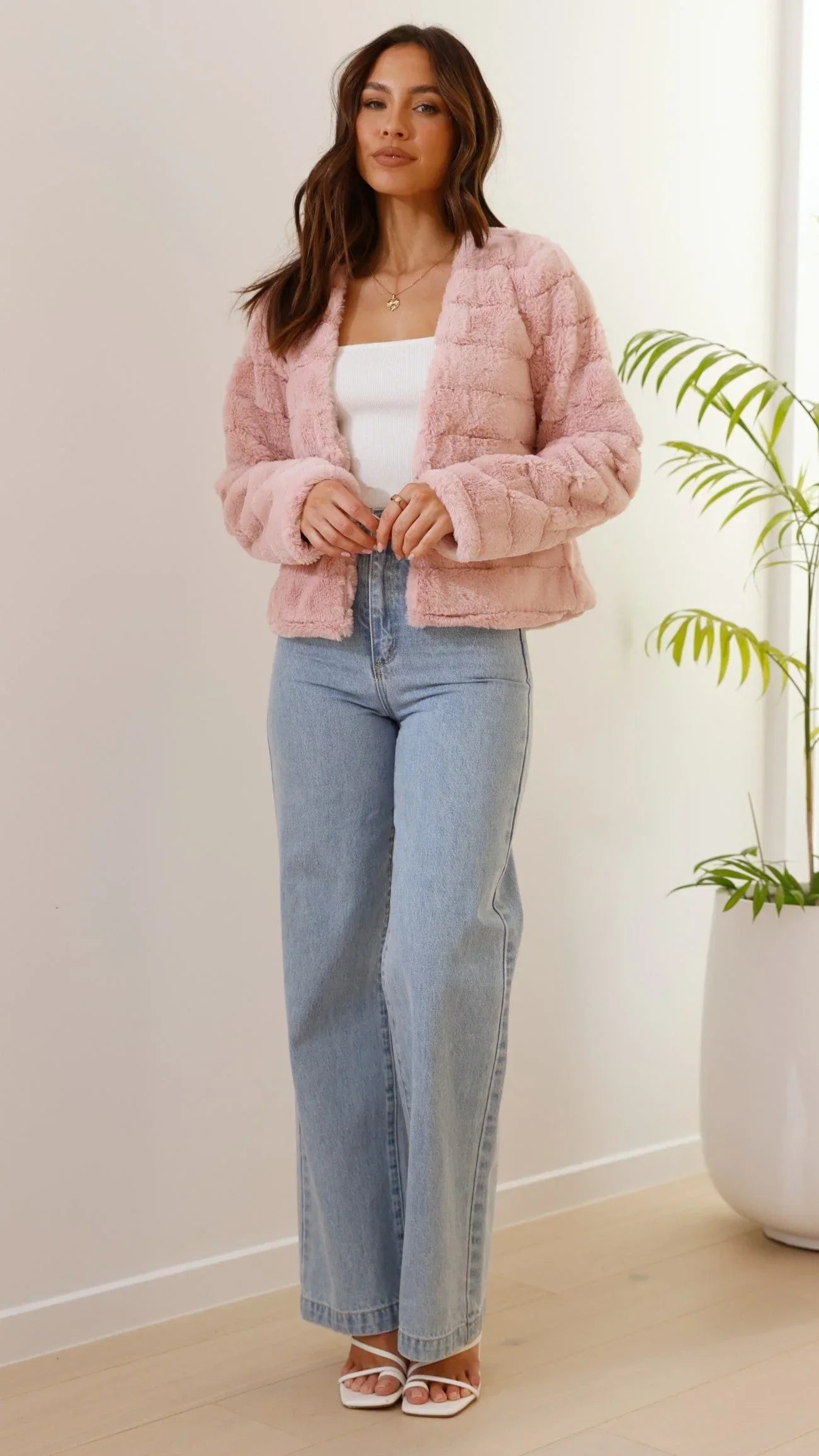 Veste courte femme en fausse fourrure blanche avec col ouvert, douce et chaude, adaptée pour les journées fraîches.
