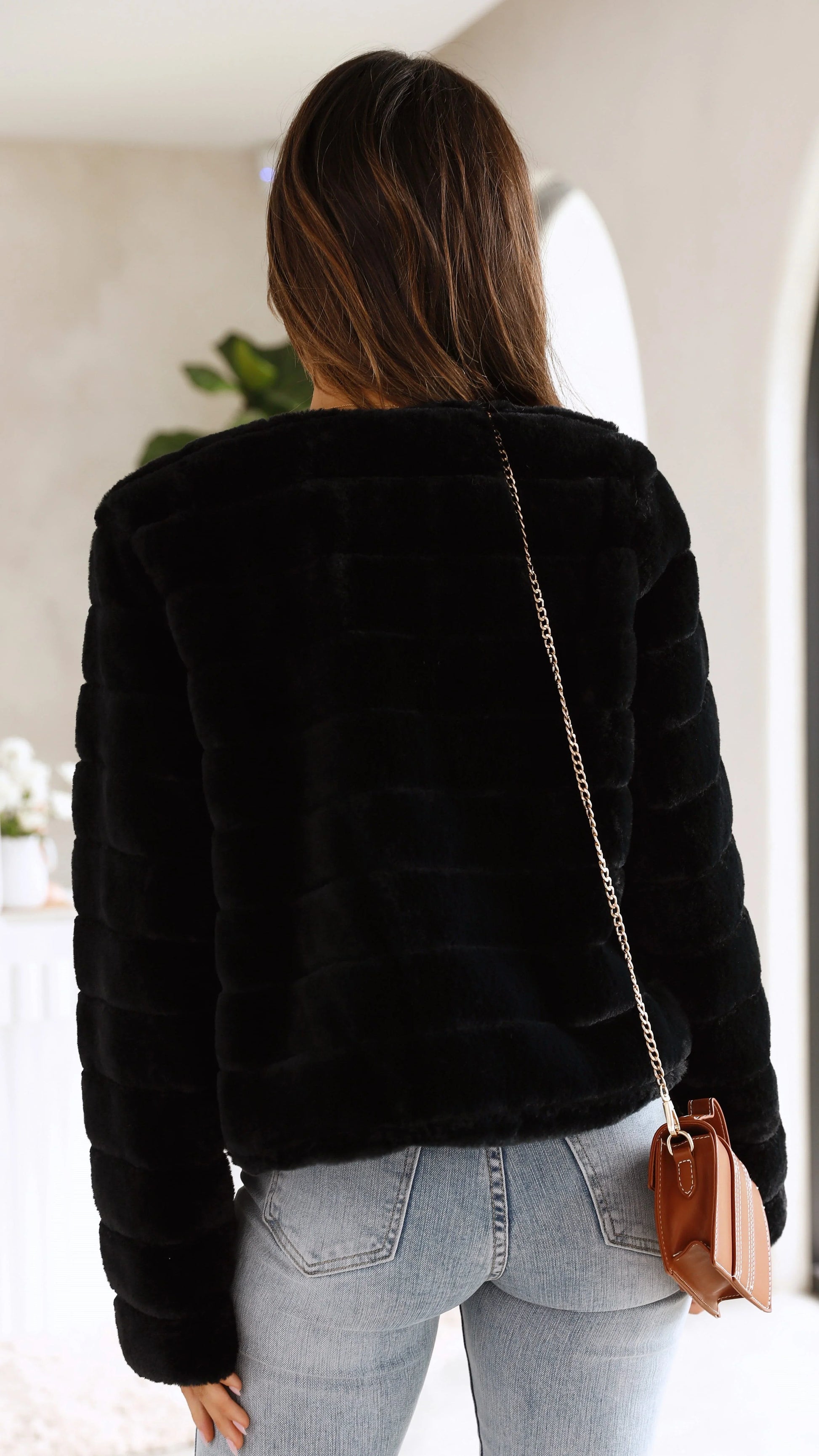 Veste courte femme en fausse fourrure grise avec col ouvert, parfaite pour les saisons intermédiaires.