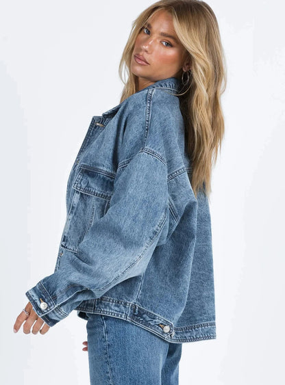 Veste en jean bleu pour femme, coupe ample, style rétro, en mélange de coton, avec poches classiques et fermeture à boutons.