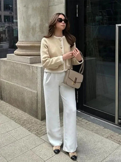 Veste courte en tweed beige pour femme avec boutons décoratifs et coupe classique.