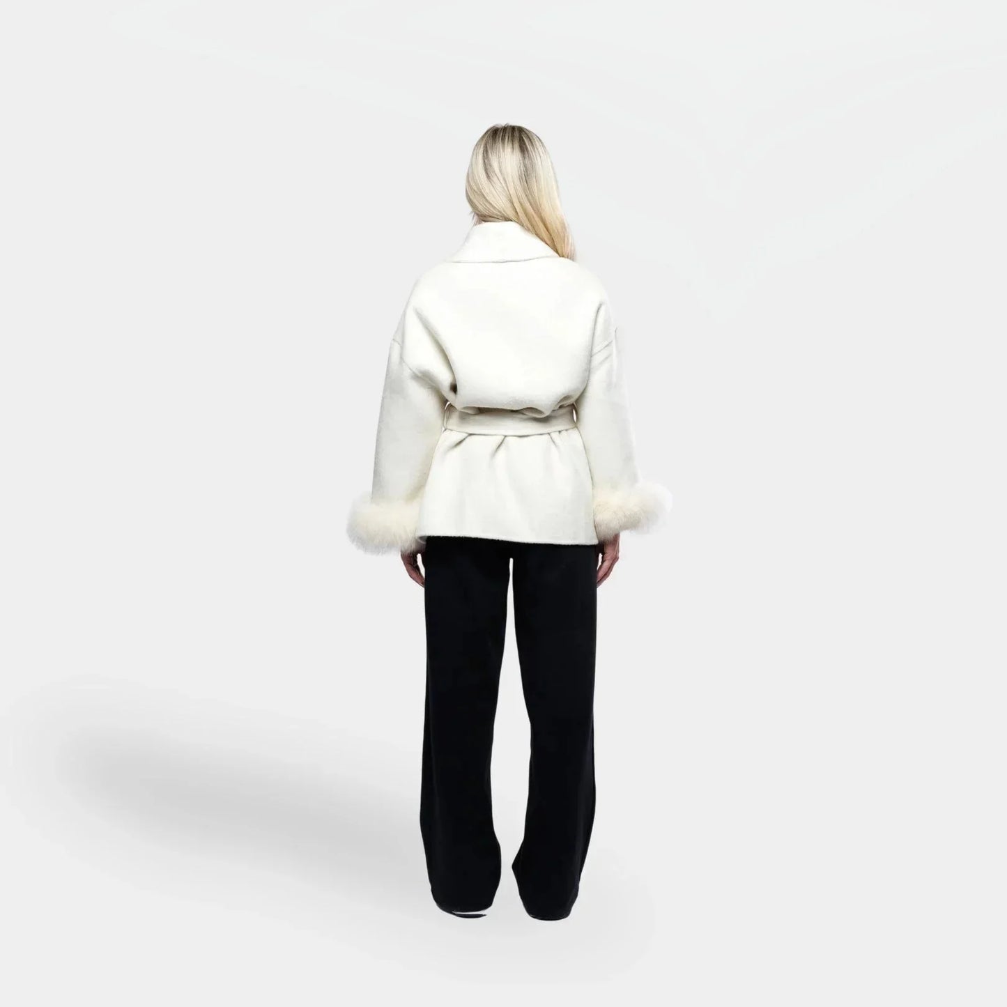 Veste blanche pour femme, ceinturée, avec manches en fourrure synthétique amovibles.