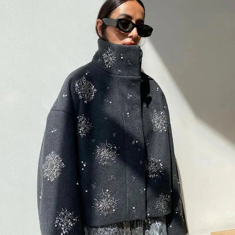 Veste femme gris avec col montant, broderie et manches chauve-souris en tissu léger.