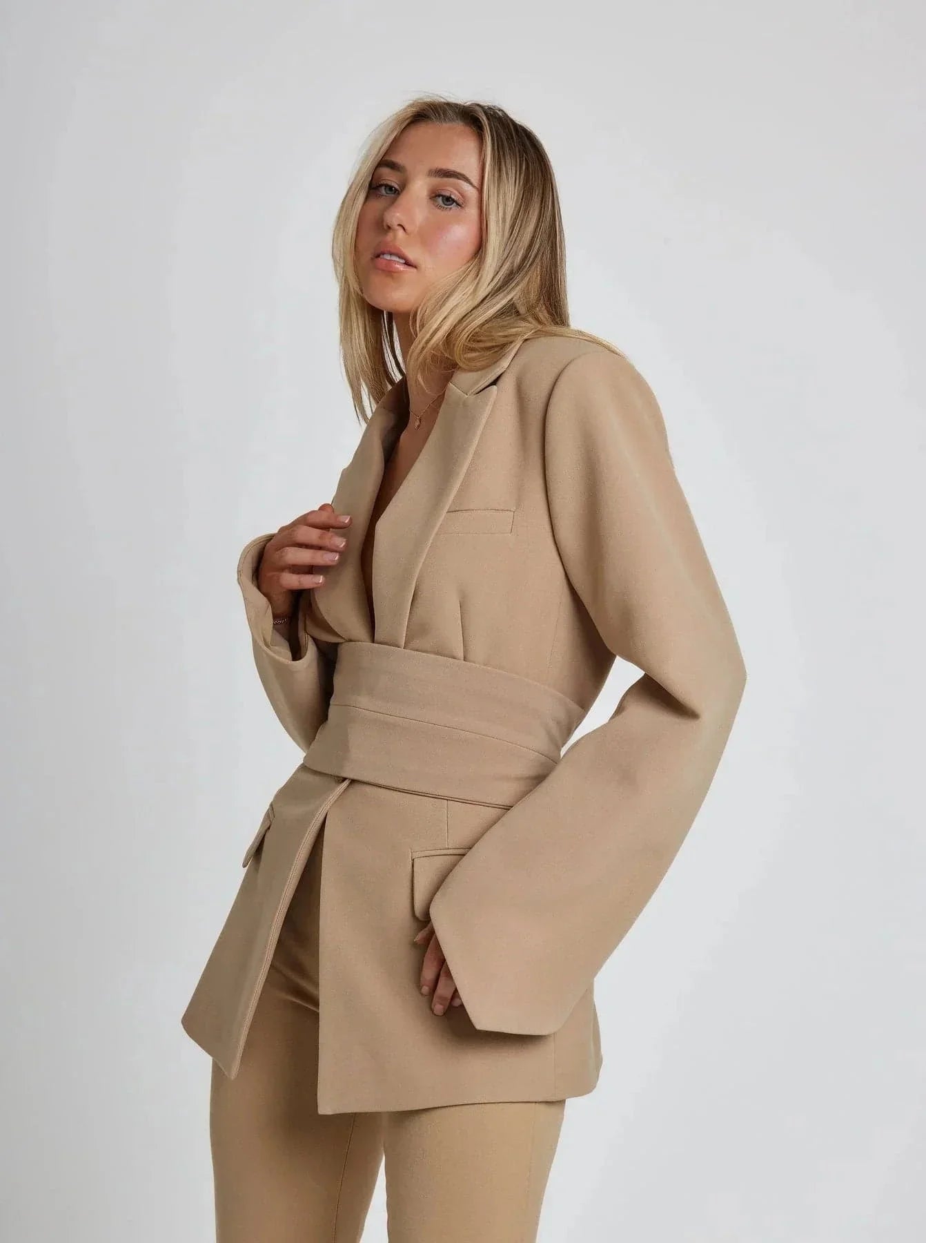 Blazer portefeuille femme kaki avec ceinture à nouer, manches longues et tissu léger.